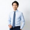 ジャケットなしでも信頼感を与える、ライトブルーのワイシャツとネクタイを着用した40代男性マネージャー⁠