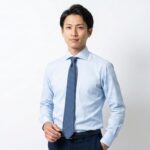 ジャケットなしでも信頼感を与える、ライトブルーのワイシャツとネクタイを着用した40代男性マネージャー⁠