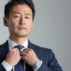 ジャストサイズのオーダースーツを着てネクタイを締める40代管理職の男性⁠